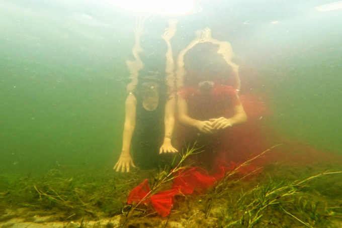 dwie osoby zanurzone pod wodą